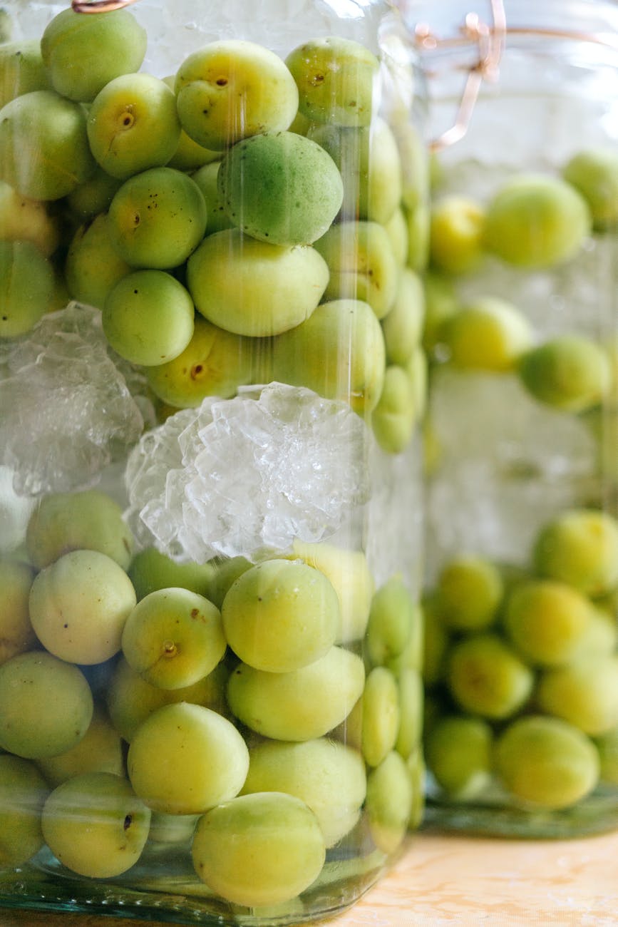 glass jar with fresh green olives and ice