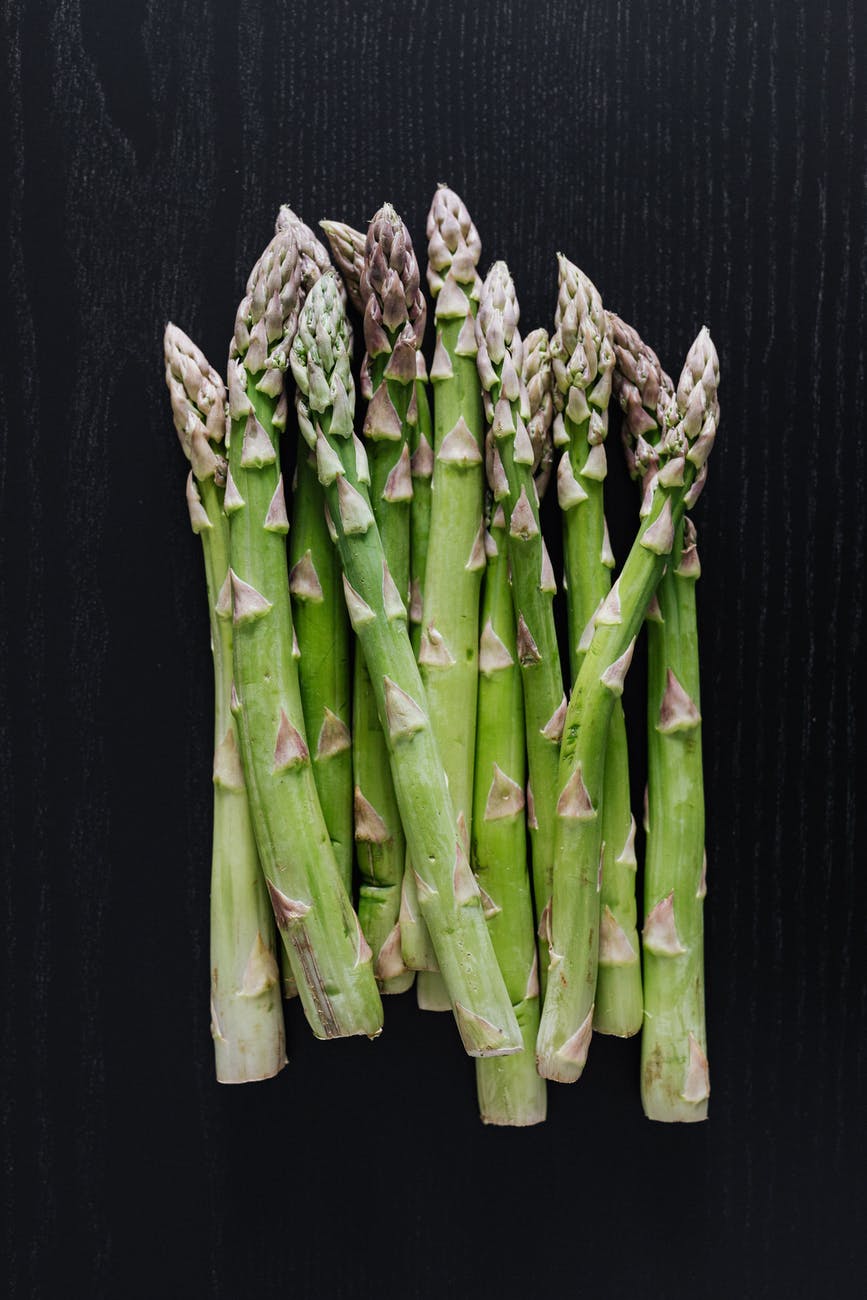 bunch of fresh green asparagus on dark table