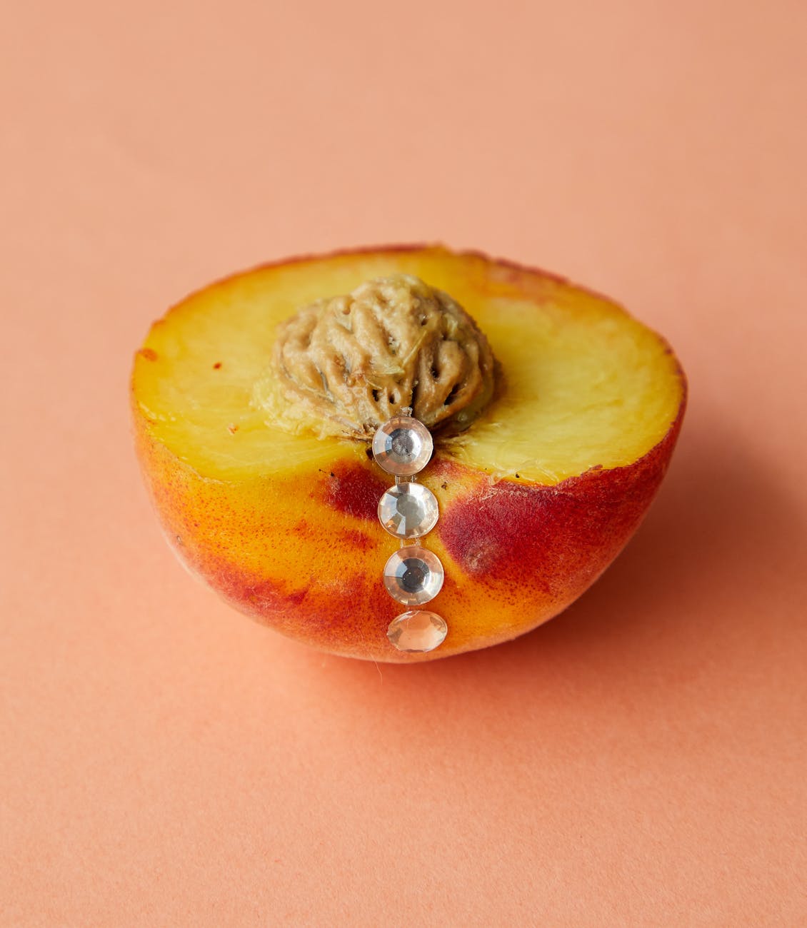 ripe cut peach with decorative rhinestones